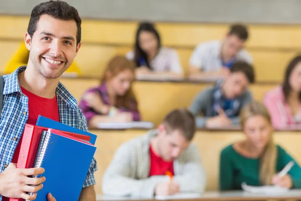 Usmívající se muž s studenti sedí v přednáškovém sále — Stock fotografie