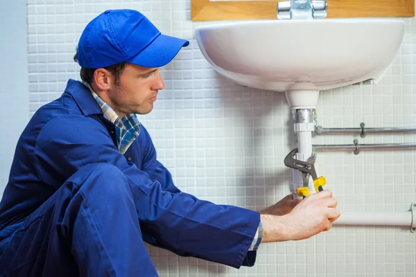 Attractive focused plumber repairing sink — Stock Photo, Image