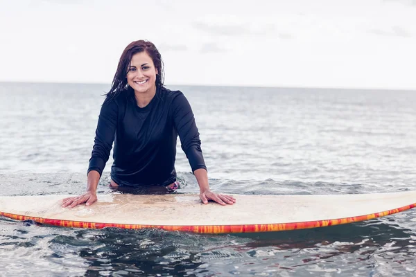 Retrato de una hermosa mujer con tabla de surf en agua — Foto de Stock