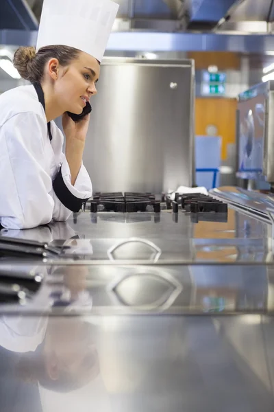 Joven chef magnífico de pie junto a la superficie de trabajo de telefonía — Foto de Stock