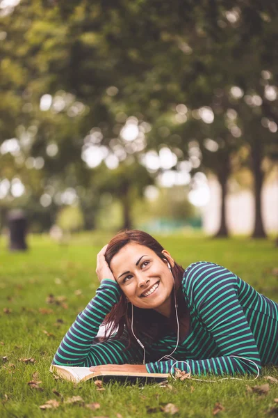 Lachende casual student liggen op gras opzoeken — Stockfoto