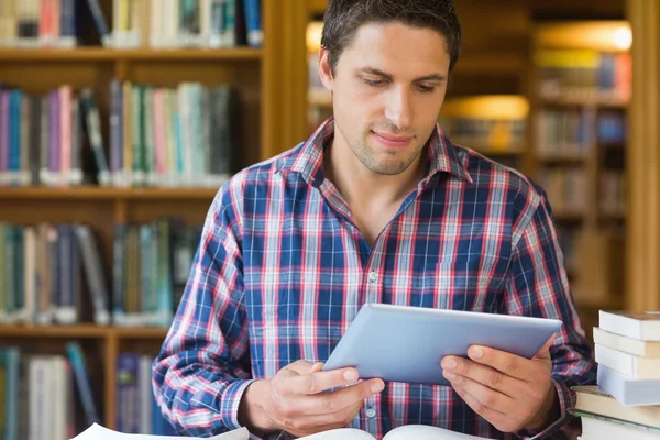 Mature student looking at tablet PC in the library — Stock Photo, Image
