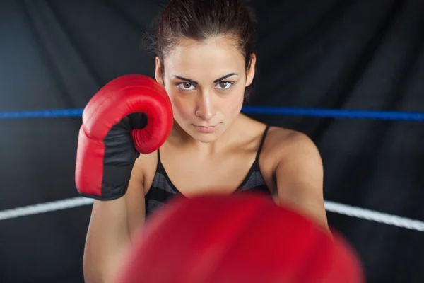 Bella donna in guanti da boxe rossi sul ring — Foto Stock