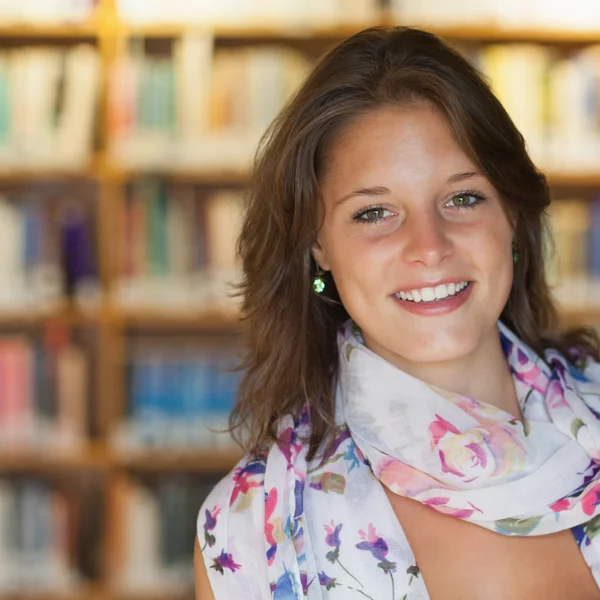 Usměvavá studentka v knihovně — Stock fotografie