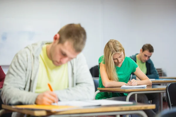 Mladí studenti psaní poznámek v učebně — Stock fotografie