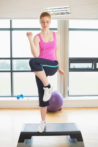 Kvinnan utför steg aerobics motion — Stockfoto