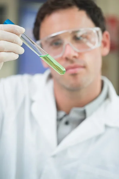 Wetenschapper analyseren groene oplossing in reageerbuis in het lab — Stockfoto