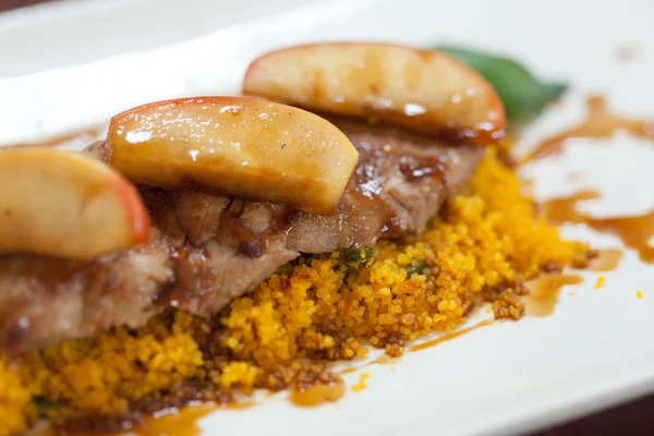 Close up van couscous met vlees gegarneerd met apple — Stockfoto