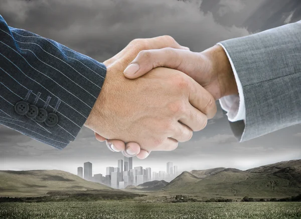 Business handshake on background of buildings and landscape — Stock Photo, Image