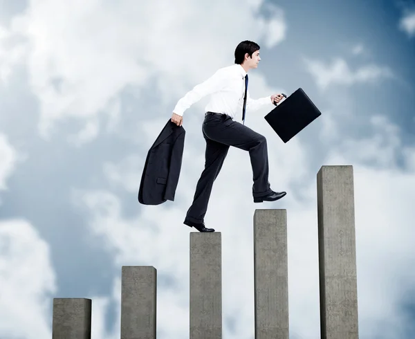 Jovem empresário escalando passos cinzentos — Fotografia de Stock