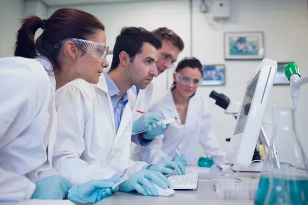 Chercheurs sérieux regardant l'écran d'ordinateur dans le laboratoire — Photo