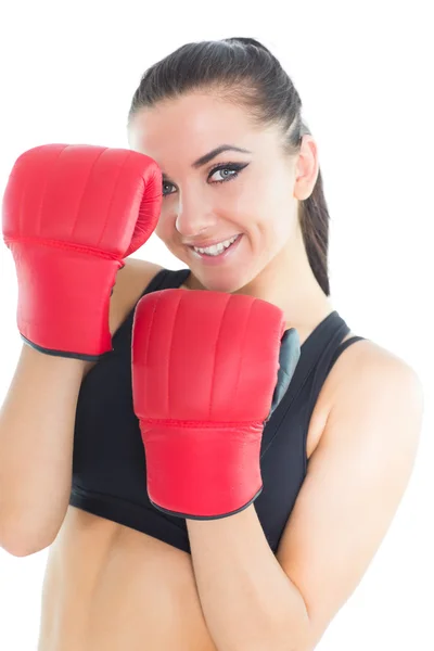 Mujer morena alegre usando guantes de boxeo sonriendo a la cámara — Foto de Stock