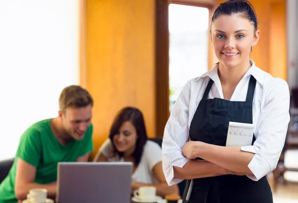 Waitress with two students using laptop at coffee shop — Stock Photo, Image