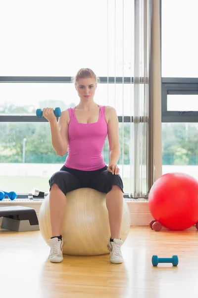 Mooie vrouw passen met dumbbell zittend op oefening bal — Stok fotoğraf