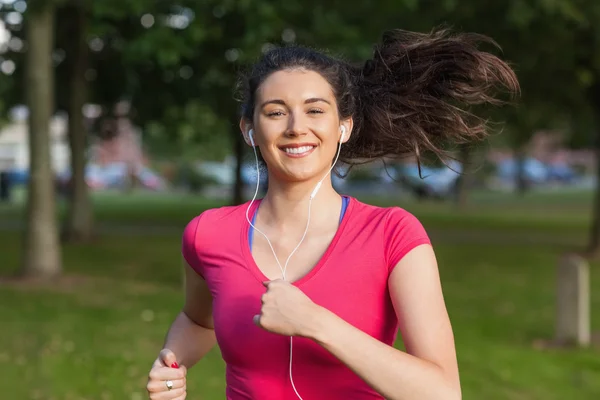 Mladá žena běží v parku — Stock fotografie