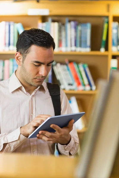 Koncentrat dojrzały student przy użyciu komputera typu tablet w bibliotece — Zdjęcie stockowe