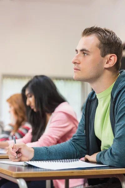 Junge Schüler schreiben Notizen im Klassenzimmer — Stockfoto