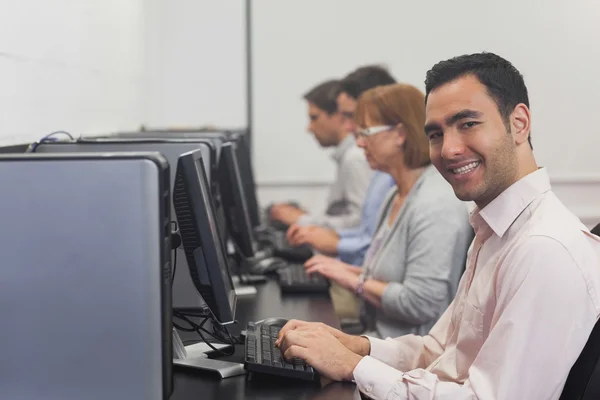 Wesoły dojrzały student siedzi w komputerze klasy — Zdjęcie stockowe