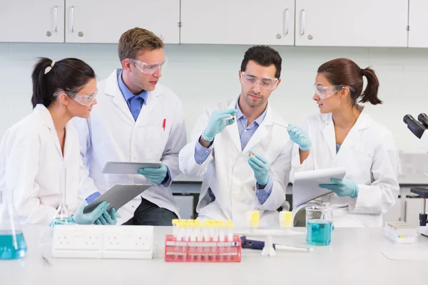 Scientists with tablet PC working on experiment at lab — Stock Photo, Image