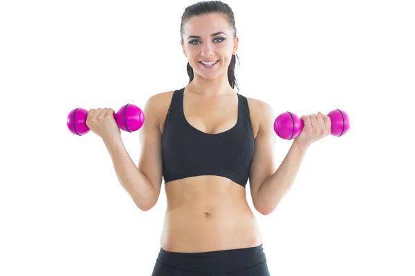 Mujer pacífica activa entrenando sus brazos con mancuernas rosadas —  Fotos de Stock