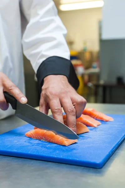 Close up of chef slicing raw salmon with sharp knife — Stock Photo, Image