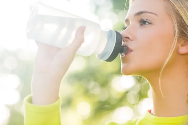 Adatta bionda che beve dalla bottiglia sportiva — Foto Stock