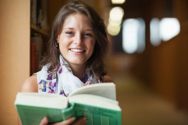 Крупный план улыбающейся студентки в библиотеке — стоковое фото