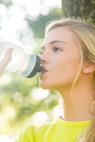 Adatta bionda che beve dalla bottiglia d'acqua — Foto Stock