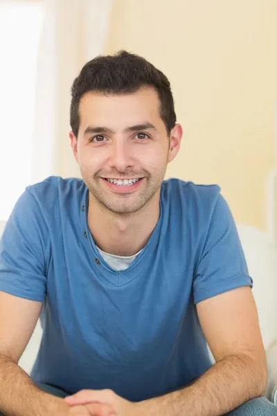 Hombre sonriente casual relajándose en el sofá — Foto de Stock