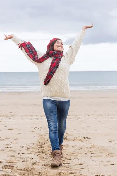 Mujer con ropa de abrigo estirando los brazos en la playa —  Fotos de Stock