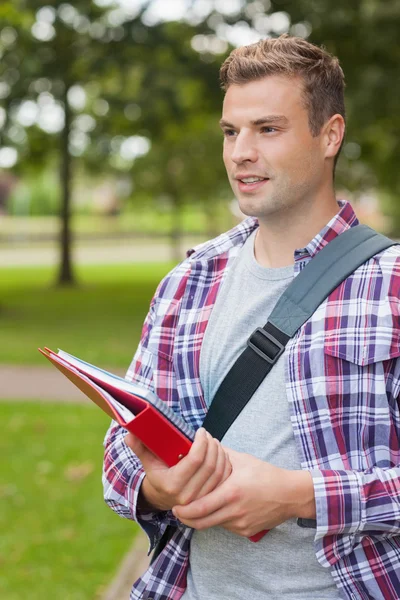 Knappe gelukkig student boekwaarde map — Stockfoto