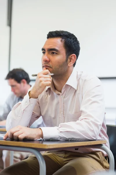 Mature students taking notes in classroom — Stock Photo, Image