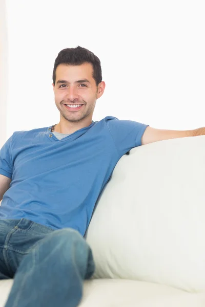 Casual homem conteúdo relaxante no sofá — Fotografia de Stock