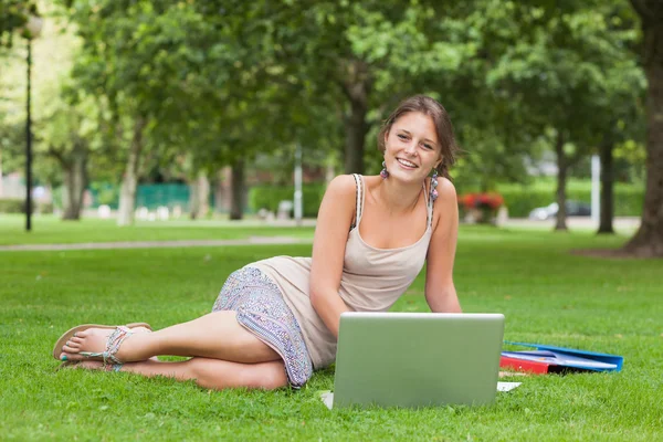 Студент с ноутбуком и книгами в парке — стоковое фото