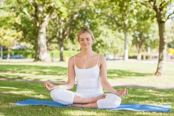 Lugn ung kvinna mediterar på en träningsmatta — Stockfoto