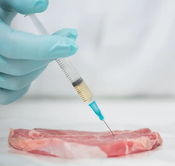 Gros plan de la main d'un chercheur ganté qui injecte de la viande — Photo