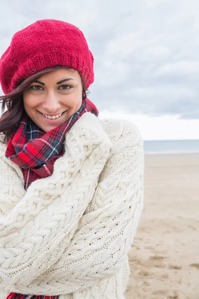 Süße lächelnde Frau in stylischer warmer Kleidung am Strand — Stockfoto