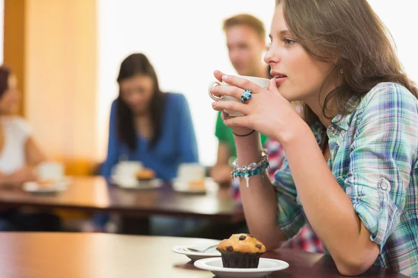 Mujer tomando café y magdalena en la cafetería — Foto de Stock