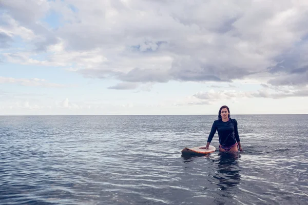 Retrato de una hermosa joven con tabla de surf en el agua —  Fotos de Stock
