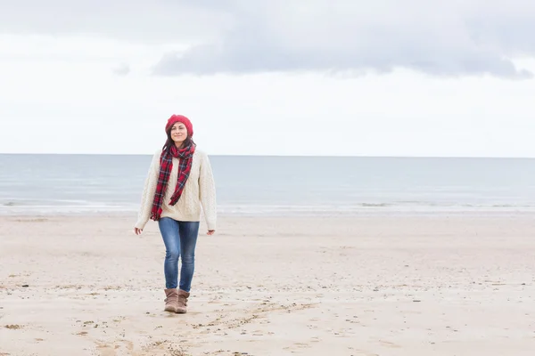 Красивая женщина в стильной теплой одежде на пляже — стоковое фото
