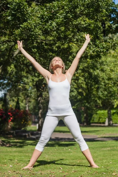 Sarışın kadın bir parkta yoga yaparken — Stok fotoğraf