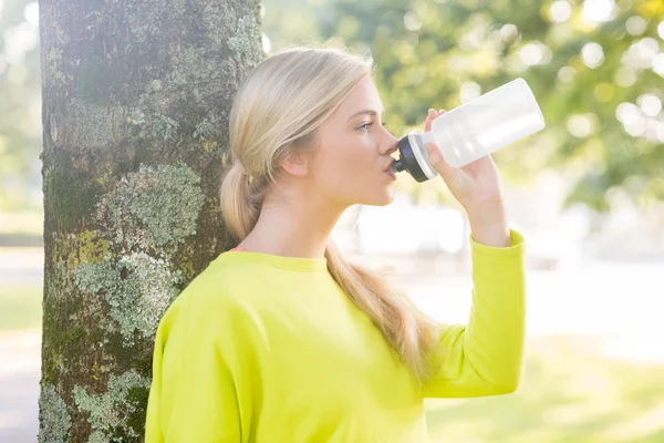 Passen vreedzame blonde drinkend uit de fles water — Stockfoto