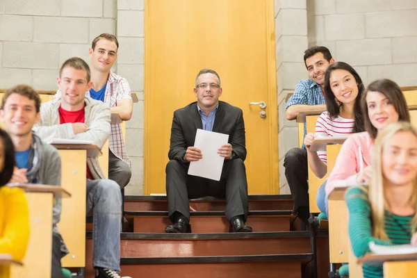 Professeur élégant avec des étudiants assis dans la salle de conférence — Photo