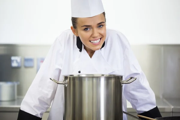 Jonge lachende chef-kok permanent achter pan — Stockfoto