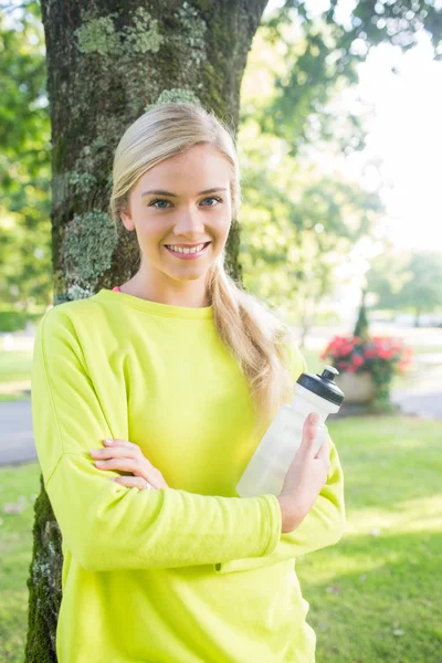 Улыбчивая блондинка держит в руках спортивную бутылку — стоковое фото