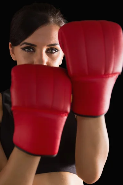 Vista frontal da jovem mulher esportiva posando usando luvas de boxe — Fotografia de Stock