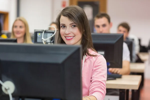 Sorridente studentessa con gli altri nella sala computer — Foto Stock