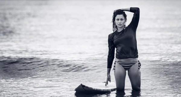 Portret van een mooie vrouw met surfboard in water — Stockfoto