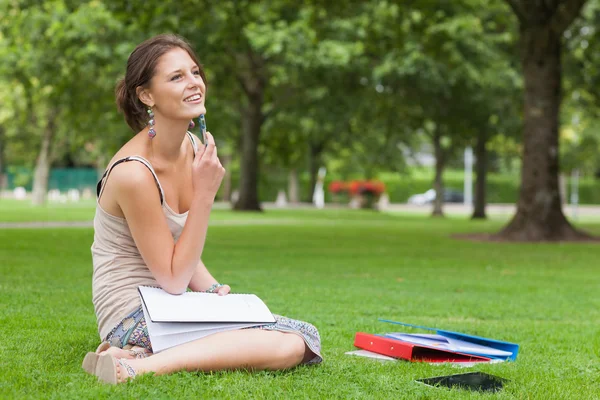 Nachdenklicher Student mit Büchern im Park — Stockfoto