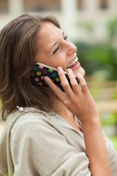 Zijaanzicht van een vrolijke vrouw met behulp van mobiele telefoon — Stockfoto